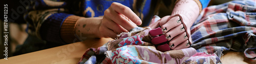 Schilderij op canvas Unrecognizable woman with prosthetic hand sorting second hand clothing on table,