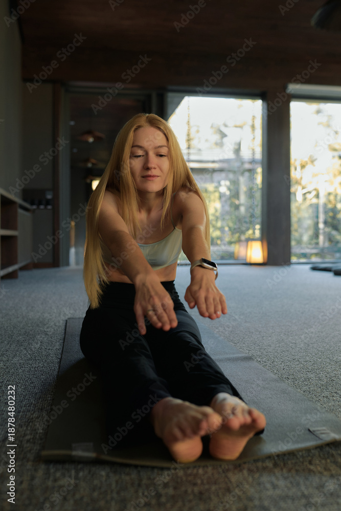 Fototapeta premium Relaxing yoga session in a serene indoor space with natural light and a calm atmosphere