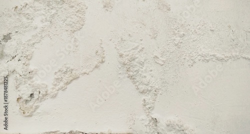 White wall paint background grumbling because it's been too long. Close up background of a white concrete cement wall that is cracked and the paint is peeling off. Old wall background wall with peelin