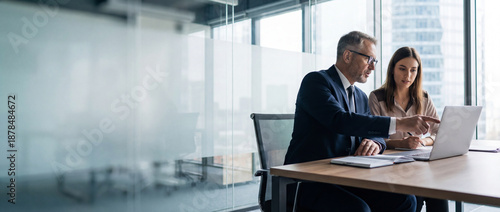 Two professional business people working together. Partners mature man and woman discussing project in office. Team leader explain trainee working process using tablet pc computer. Banner, copy space