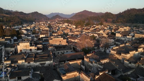 Xidi, China: Aerial forward drone footage of the famous Xidi ancient village with narrow street, temples and water steams near Huangshan in Anhui province in China at sunset