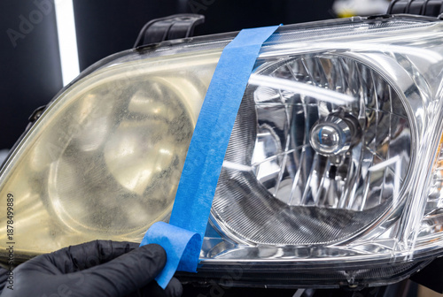Before and after result of car headlight restoration separated by blue tape being peeled off