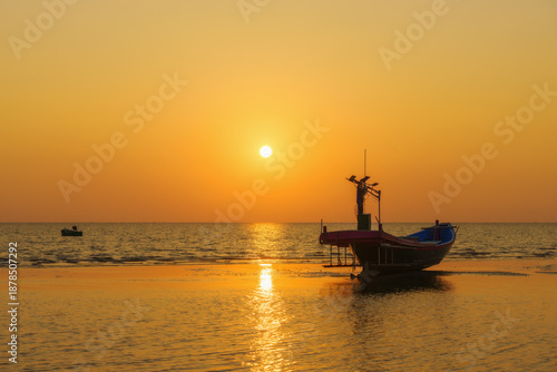 Fishing boats on the beach when the sun begins to set with a beautiful backdrop of sea and sand.