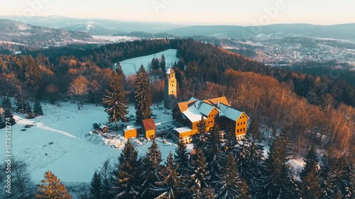 Explore the Bramberk lookout tower in the Jizera Mountains during winter. Snow covers the ground while trees surround this historic site. Get a view of the landscape and enjoy the winter scenery.