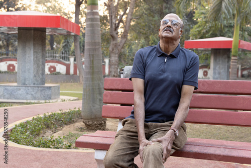 Obraz na plátne Portrait of a Indian senior man suffering from knee pain at park