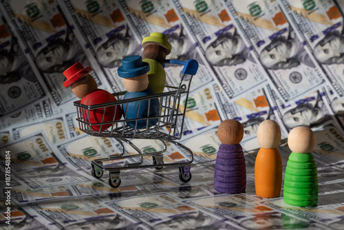 Symbolic wooden people in a miniature shopping cart against a backdrop of $100 bills