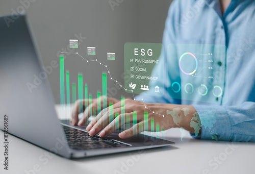 Business professionals are using digital interfaces that showcase ESG concepts, sustainability, energy, renewable energy, environment, sustainability analytics, and green investment.