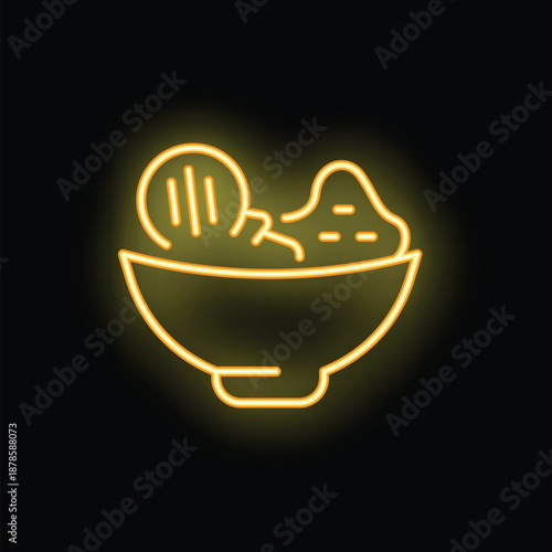 Bright yellow neon sign of a bowl of fresh salad is glowing on a black background