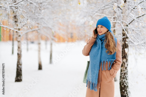Wallpaper Mural Woman walks through her yard in winter, talking on the phone. The woman is wearing a hat and scarf Torontodigital.ca