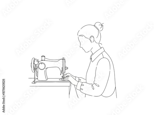 A woman sitting and using a sewing machine with focus
