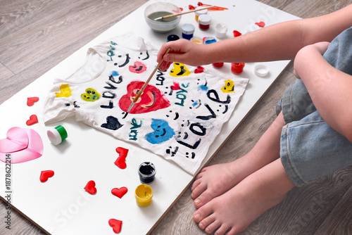 Teenager girl sitting on the floor and painting coloring white t shirt. Creative. Gift for Mothers day, Fathers day, Birthday, Valentines day. Kid craft. Home education game. Kids leisure activity
