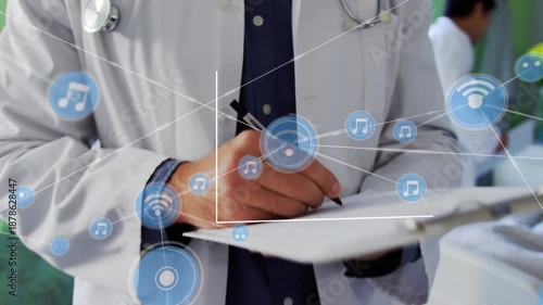 The doctor is writing on a clipboard in the ward