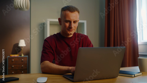 Man remote worker get ready work home. Guy come early morning sit down desk open laptop type keyboard. Male employee surfing net. Busy serious person use pc. Online computer freelancer. Distant job.