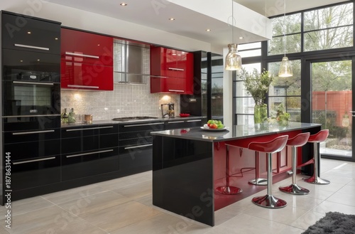 Sleek contemporary kitchen featuring glossy red and black cabinetry, a modern island with stools, and elegant lighting