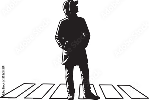 Silhouette of a young man standing on a crosswalk