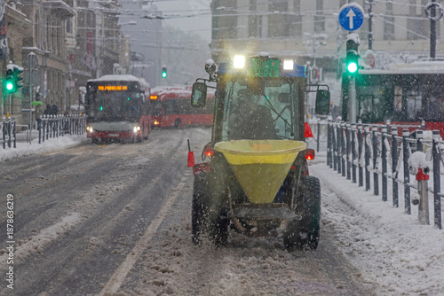 Obraz na plátně Snowplow Salt Spreader Tractor Cleaning City Streets at Cold Winter Dusk