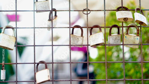 Multiple Padlocks on Metal Fence Background. Padlocks attached to a metal fence forming a repetitive pattern, ideal for concepts of safety, control, and protection