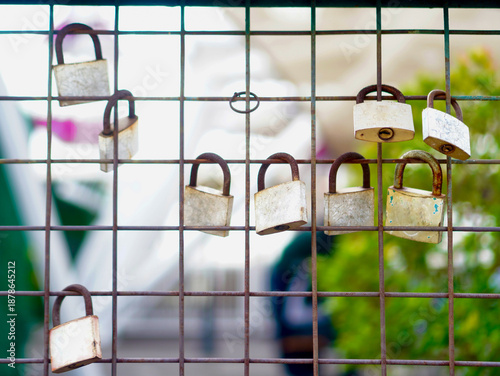 Locked Fence with Old Padlocks and Rust Texture. Detail of old rusty padlocks on a fence, highlighting industrial textures and themes of restriction and security
