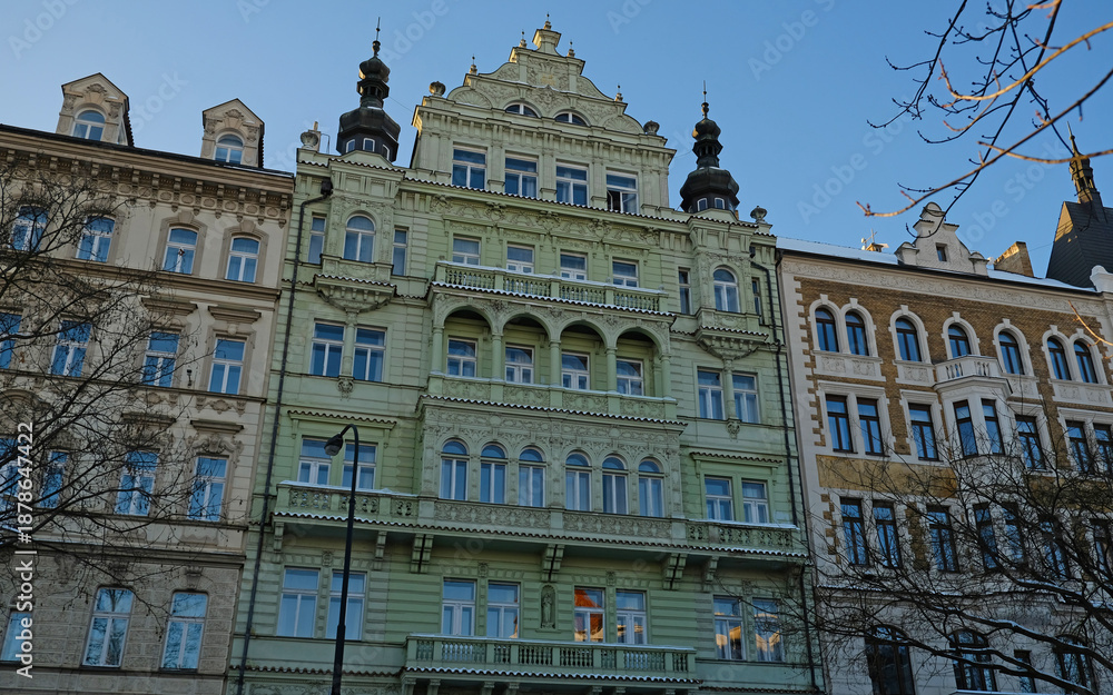Fototapeta premium Typical Historic Prague architecture, ornate Neo-Renaissance and Neo-Baroque facades. Exterior view of cozy residential buildings with windows with molding. Real estate, Living apartment