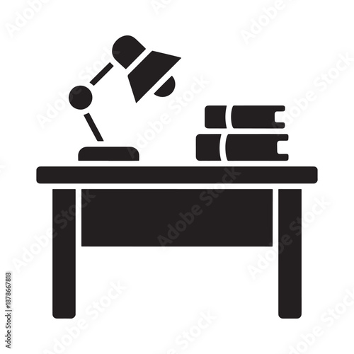 A simple desk setup with a lamp and stacked books is shown