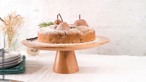 Rustic Pear and Spiced Cake Dusted with Powdered Sugar on Wooden Stand