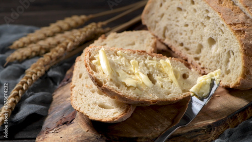 Fresh Sourdough Bread Sliced with Butter on a Rustic Wooden Board