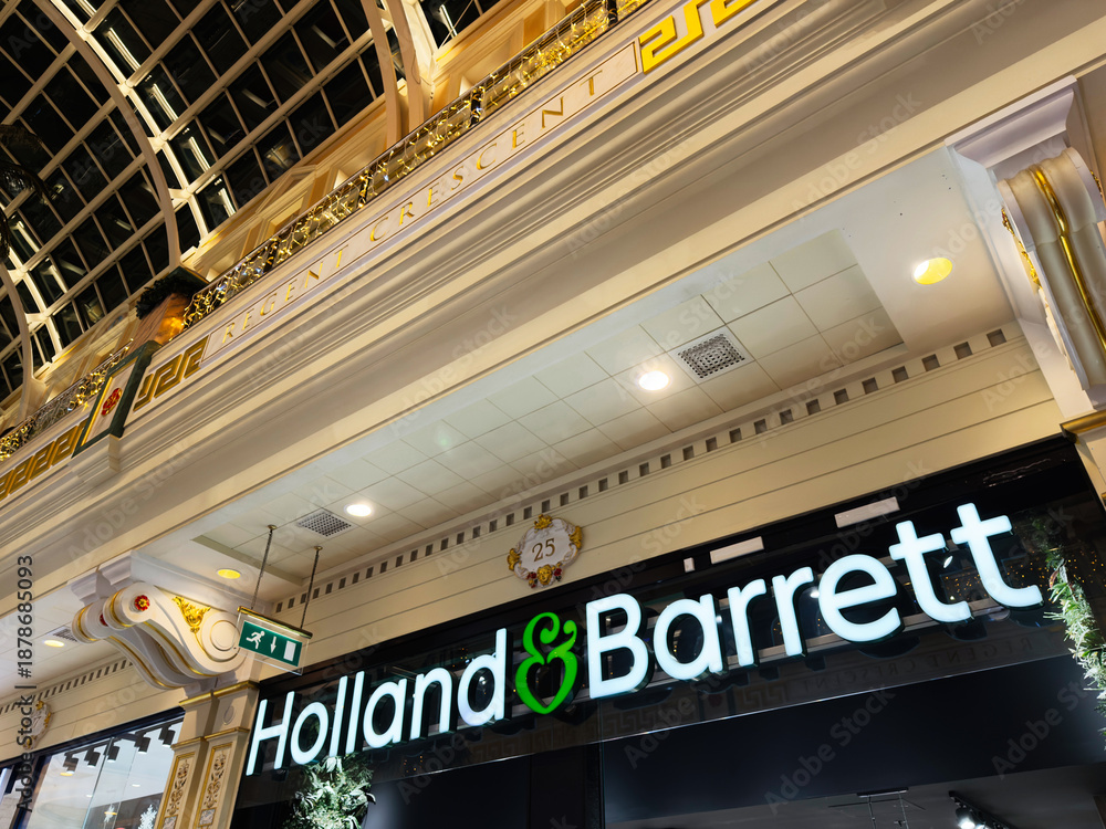 Fototapeta premium Holland Barrett storefront in ornate Manchester shopping arcade interior at night