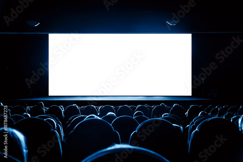 People in the cinema watching a movie. Blank empty white screen