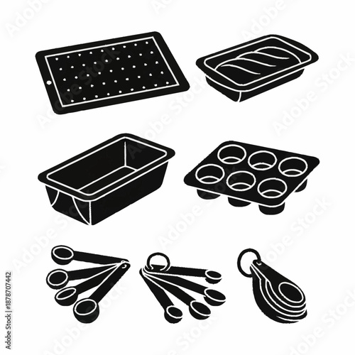 Collection of baking pans and measuring spoons for kitchen use.