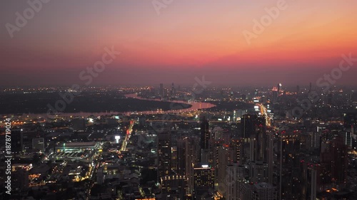 Wallpaper Mural Aerial view of Bangkok at dusk, city lights twinkling below colorful sky and the Chao Phraya River curving through the urban landscape from a unique perspective Torontodigital.ca
