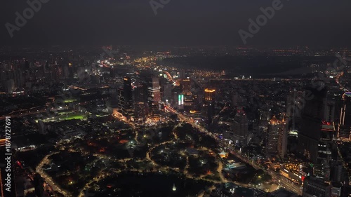 Wallpaper Mural Elevated night view of Bangkok, Thailand, showing illuminated city skyline, busy streets, and green expanse of Lumphini Park Torontodigital.ca