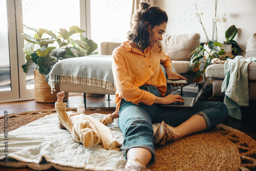 Mother working from home with baby and laptop