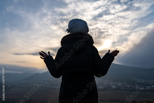 Εκτύπωση καμβά Silhouette sunset freedom woman standing on mountain ridge with arms outstretche