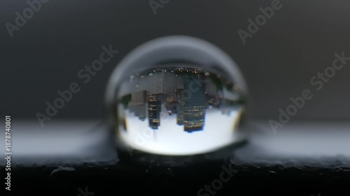Macro shot of a water droplet reflecting a city skyline.