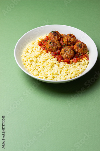 Pasta ptitim with meatballs in tomato sauce. Italian cuisine.
