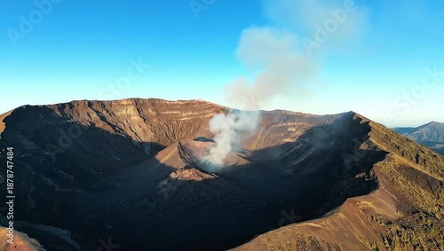 Majestic Volcano Crater Emitting Steam Under a Clear Blue Sky.
