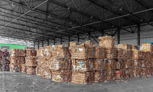 Obraz na plátně Stacked cardboard bales in industrial recycling center warehouse