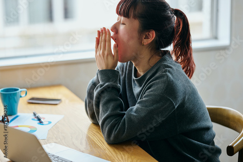 A young woman yawning and looking sleepy