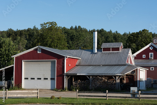 Red and White Barn and Farmhouse with Stacked Logs