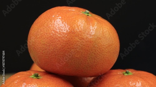 Tangerines coming into focus on dark background. Ideal for revealing fresh ingredients in culinary or healthy lifestyle videos.