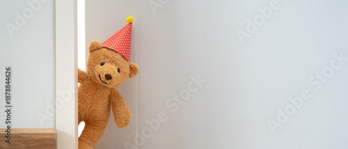 Foto Teddy bear playing hide and seek behind the door, Adorable child having fun in the home