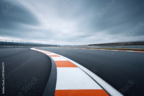 Curved racing track under dramatic sky, showcasing smooth asphal