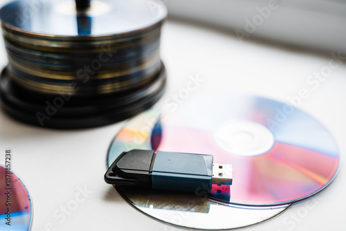 фотографія Bunch of CD and DVD discs with USB flash drive placed on them.