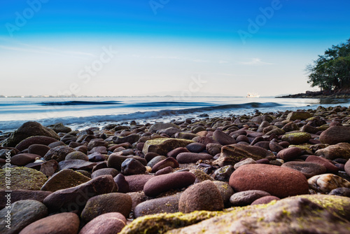 Close-up of smooth stone beach ocean background.
