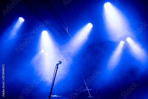 microphone on stage, smoke and blue light, no people, backlight