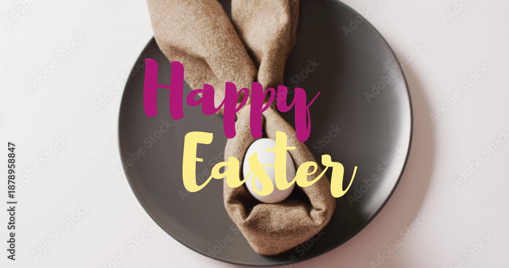 Fototapeta premium Image of happy easter text over white easter egg in cloth on black plate on white background