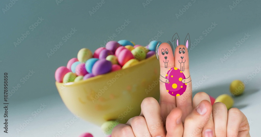 Fototapeta premium Image of fingers with easter bunny faces and easter eggs on blue background