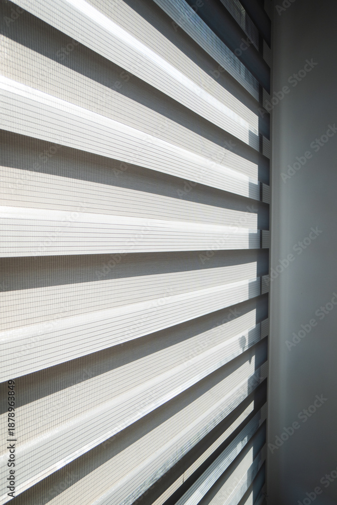 Obraz premium Modern window with zebra roller blinds and chain mechanism detail, contemporary apartment interior and daylight control concept