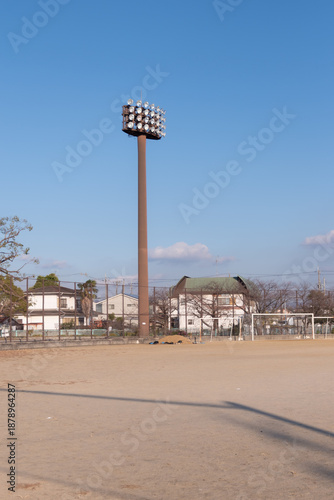 放課後の静かな土のグラウンドとサッカーゴール、日本のアニメ風の風景（部活・ノスタルジー）