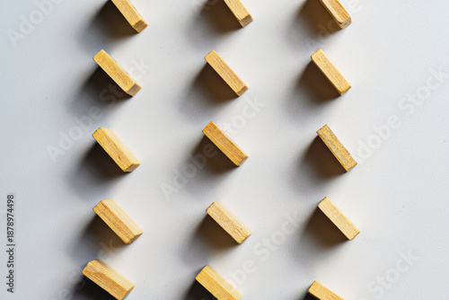High-angle view of small wooden rectangles arranged in a diagonal grid pattern on a clean white surface. Perfect for background, design concepts, and abstract themes